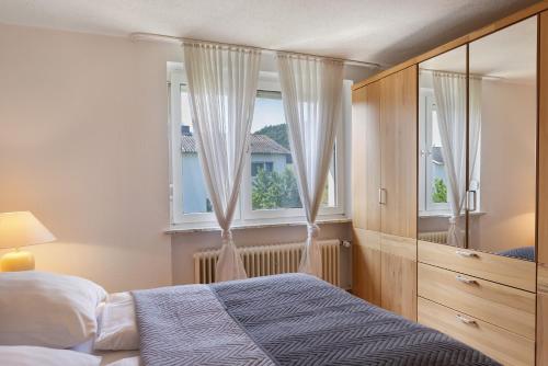 a bedroom with a bed and a window with curtains at Haus Lerchenweg in Bad Wildungen