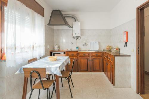 a kitchen with a table and some chairs in a room at Casa Margarida Malveiro in Odeceixe