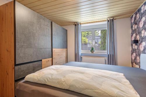 a bedroom with a bed and a window at Ferienwohnung Högenbachtal in Pommelsbrunn