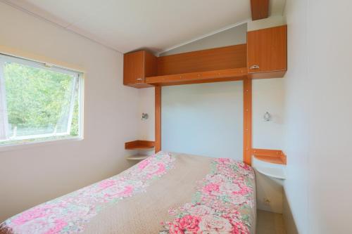 a small bedroom with a bed and a window at Mobil home 1 Loft in Plouha