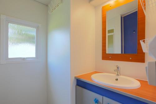 a bathroom with a sink and a mirror at Mobil home 1 Loft in Plouha