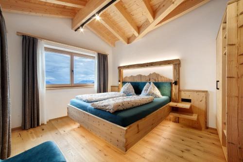 a bedroom with a bed and a large window at Oberplatzer in Lagundo
