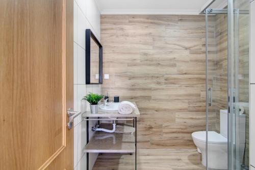 a bathroom with a toilet and a glass shower at Quinta Alegre Tavira Moderno T2 in Luz de Tavira