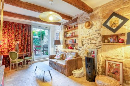エーグ・モルトにあるLa Maison Dans Les Rempartsのソファと石壁のあるリビングルーム