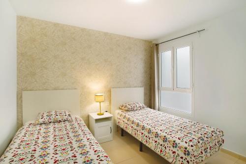 two beds sitting next to each other in a bedroom at Sunrise Arinaga in Arinaga
