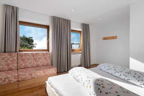 a room with two beds and a couch and a window at Kardinerhof in Collalbo