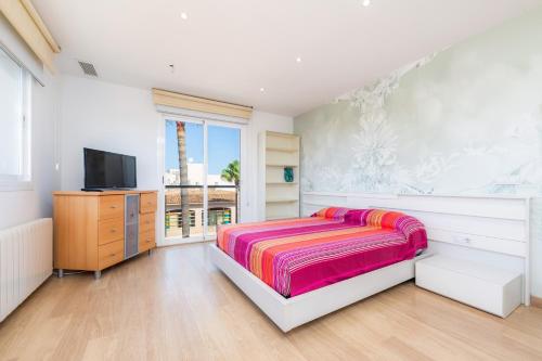 a bedroom with a bed and a flat screen tv at Ático Las Palmeras in Cala Millor