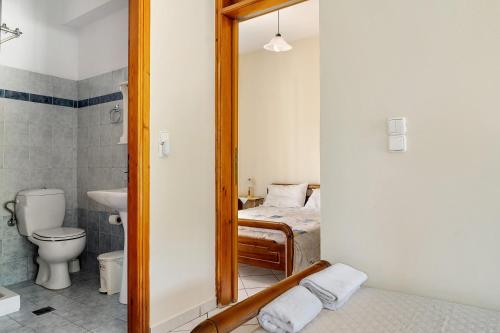 a bathroom with a toilet and a bed and a mirror at Daratos apartment 3 in Kefallonia