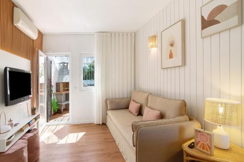 a living room with a couch and a tv at Casa da Gomeira in Conceição