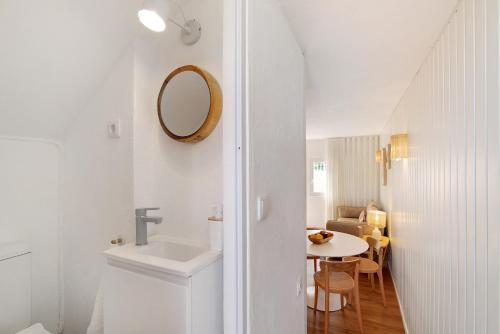a bathroom with a sink and a mirror and a table at Casa da Gomeira in Conceição