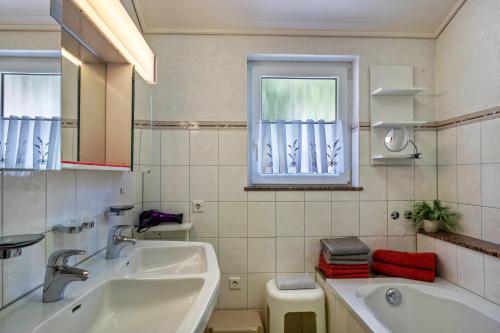a bathroom with a sink and a tub and a window at Unterfalkenhof in Schramberg
