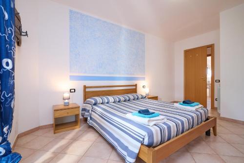 a bedroom with a bed with blue and white stripes at Blu - Euroappartamenti in San Vincenzo