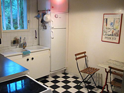 a kitchen with a refrigerator and a table and a chair at Haus Zypresse in Saint-Saturnin-lès-Apt