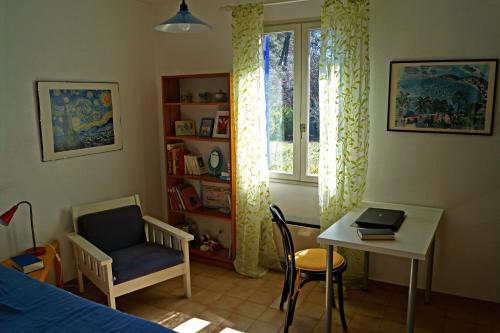 a bedroom with a bed and a desk and a window at Haus Zypresse in Saint-Saturnin-lès-Apt