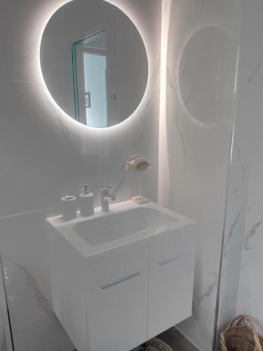 a bathroom with a white sink and a mirror at Limani Cottage in Steni Vala Alonissos