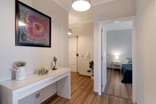 a living room with a table and a painting on the wall at Palmeira Galé in Galé