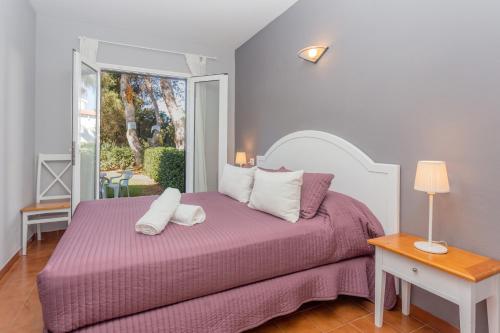 a bedroom with a bed with a purple bedspread at Villa Seve in Cala en Bosc