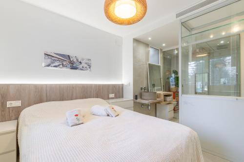 a bedroom with a white bed and a bathroom at Albir Playa in Alfaz del Pi