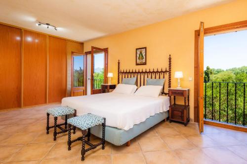 a bedroom with a bed and a balcony at Finca Ca'n Terrasa in Capdepera