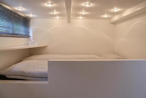 a white room with a bed and a window at Tiny Haus an der Schlei in Kosel