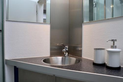 a bathroom counter with a sink and a mirror at Tiny Haus an der Schlei in Kosel