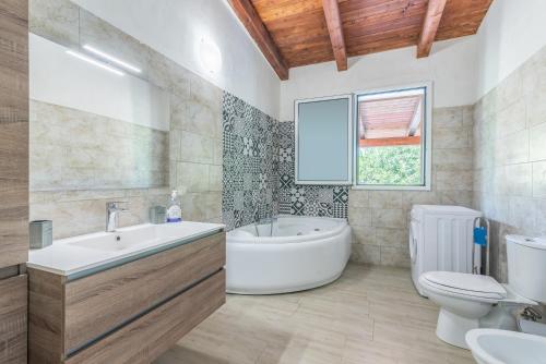 a bathroom with a tub and a toilet and a sink at Villa Lorenzo in Avola