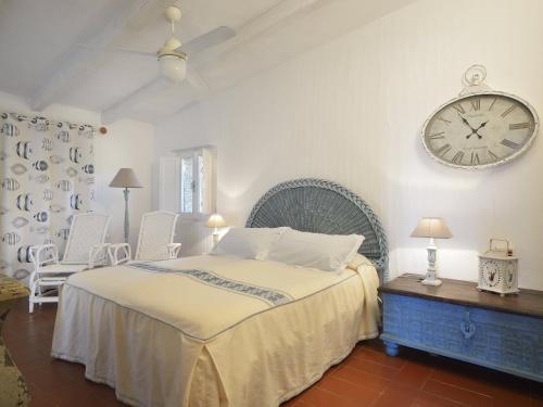 a bedroom with a bed and a clock on the wall at Casa 23 in Castiadas