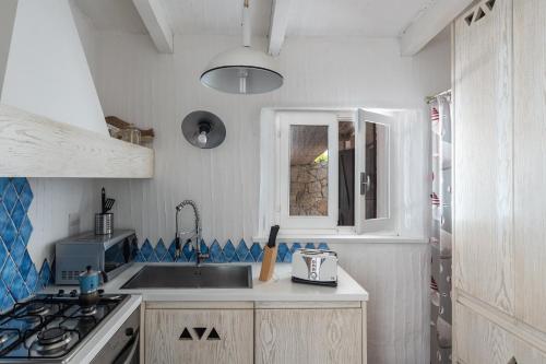 a small kitchen with a sink and a stove at Casa 23 in Castiadas
