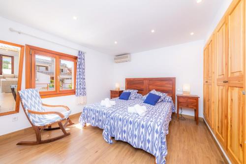 a bedroom with a bed and a chair in it at Can Binitu in Capdepera
