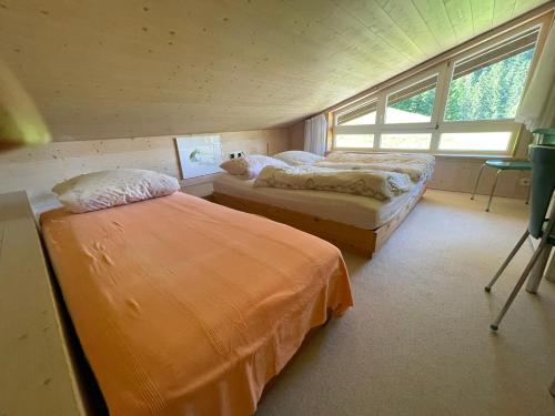 a bedroom with two beds and a window at Fewo 1 am Auweg in Hirschegg