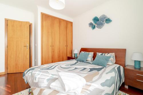 a bedroom with a bed and a clock on the wall at Lagoa Residence in Esposende