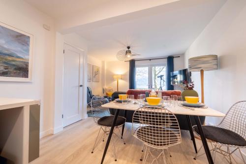 a dining room and living room with a table and chairs at Faodail in Onich