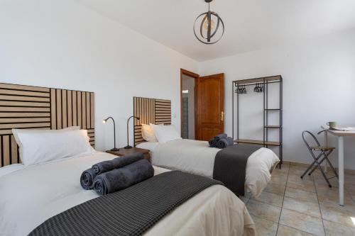 a hotel room with three beds and a table at El Pico in La Santa