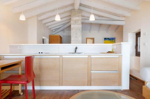a kitchen with a sink and a red chair at Haus mit tollem See -und Bergblick in Gargnano