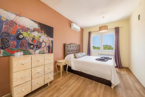 a bedroom with a bed and a painting on the wall at Nikydan in Cala d´Or