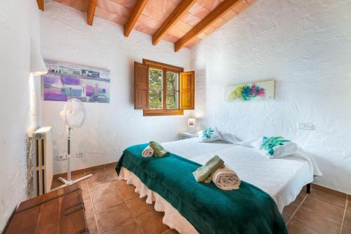 a bedroom with a bed in a white room at Yuma in Llucmajor