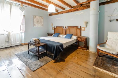 a bedroom with a large bed and a chair at Laguna Herrera in Campo de Cuéllar