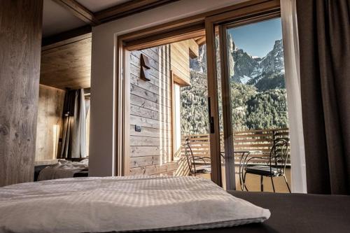 a bedroom with a large window with a mountain view at Mysciliar Apartment Sky ii in Siusi