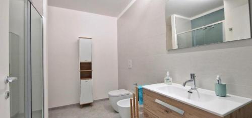 a white bathroom with a sink and a toilet at Villa Taliala in Alcamo Marina