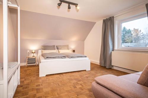 a bedroom with a white bed and a window at Ferienwohnung Allgäu in Kißlegg