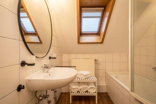 a bathroom with a sink and a mirror and a tub at Ferienwohnung Allgäu in Kißlegg
