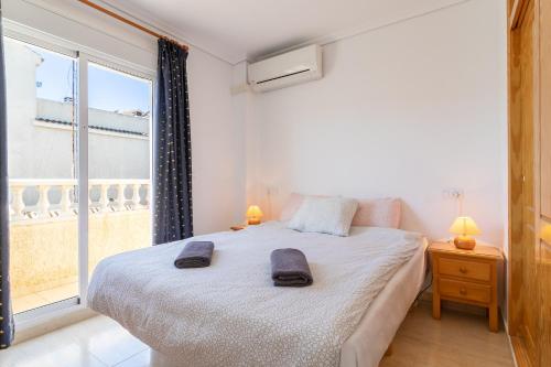 a bedroom with a bed and a large window at Bungalow Desired Track in Santa Pola