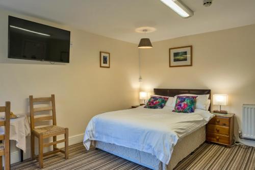 a bedroom with a bed and a flat screen tv at finest Retreats - Trimstone Manor, Lee Studio Apartment in Woolacombe