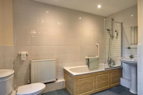 a bathroom with a toilet and a tub and a sink at finest Retreats - Trimstone Manor, Lee Studio Apartment in Woolacombe