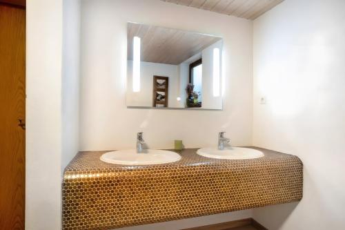 a bathroom with two sinks and a mirror at Gästehaus Panorama - Appartement 2 in Reit im Winkl