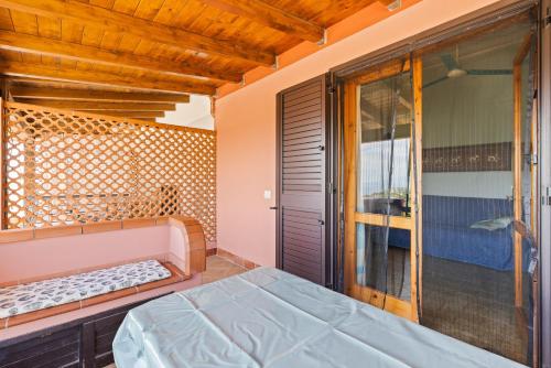 a bedroom with a bed and a glass door at Casa Erbì in Torre Dei Corsari