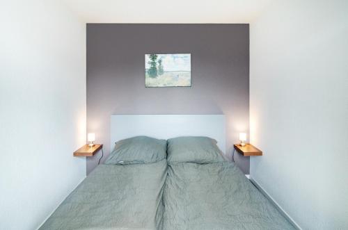 a bedroom with a bed with two lamps on the sides at Ferienwohnung am West-östlichen Tor in Ecklingerode