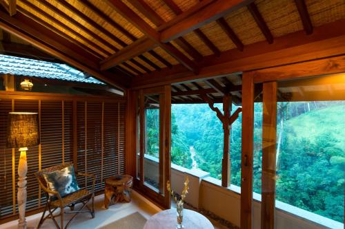 a room with large windows and a table and a lamp at Ulun Ubud Resort - CHSE Certified in Ubud