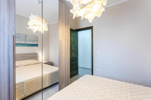 a bedroom with a mirror and a bed at Casamorle in Isola Rossa
