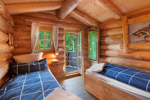 una camera da letto in stile baita con un letto e una finestra di Tiny Hideaway Bayerischer Wald a Sankt Englmar